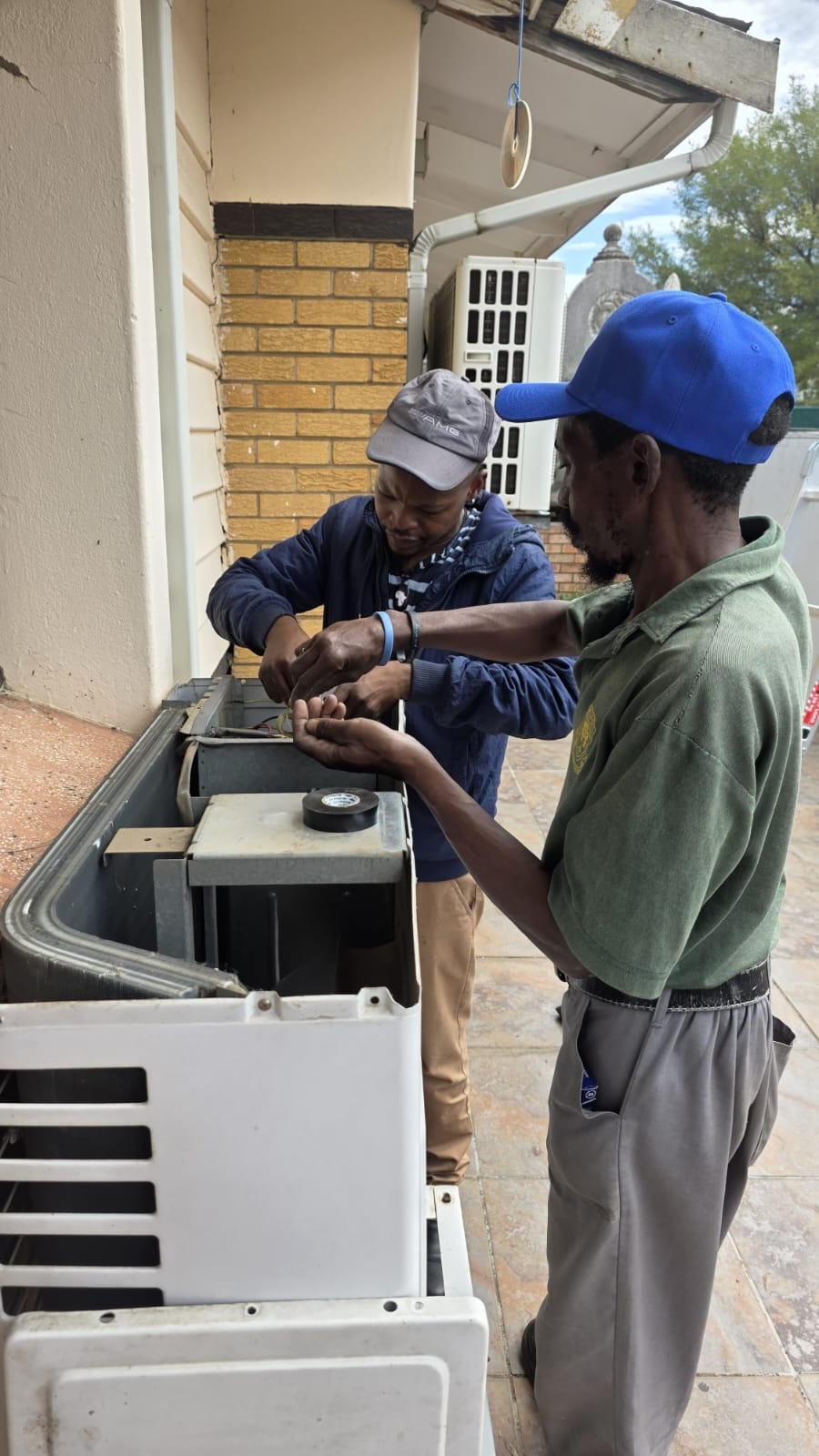 NOVA Cool technicians repairing the wiring of an air-conditioning indoor unit